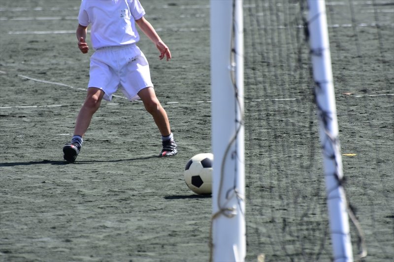 グラウンドでサッカーを行う生徒。中学生はやりたい部活の有無で隣接校を申請する場合もある
