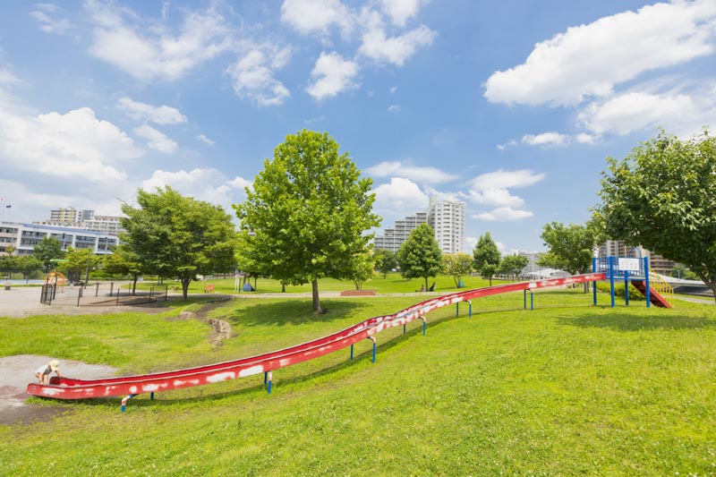 「新田さくら公園」の芝生広場とローラー滑り台
