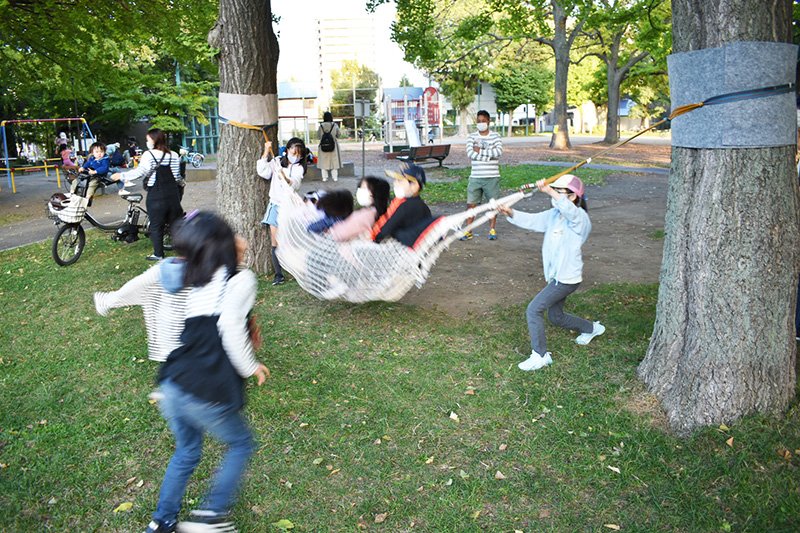 桑園公園の木にくくりつけたハンモックを揺らして遊ぶ子どもたち