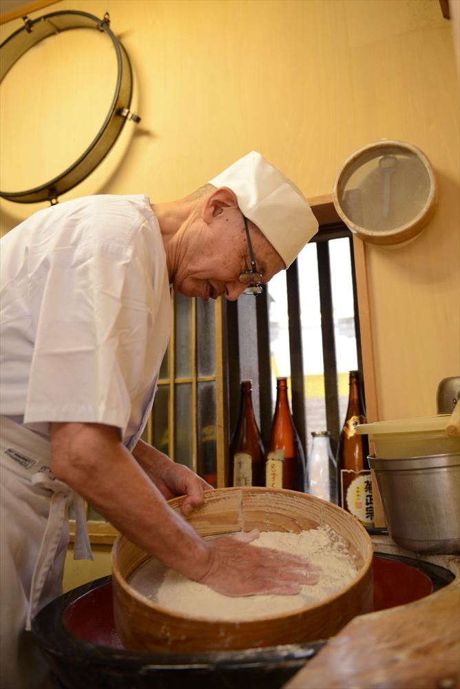 熟練の技でそばを打つ村松さん