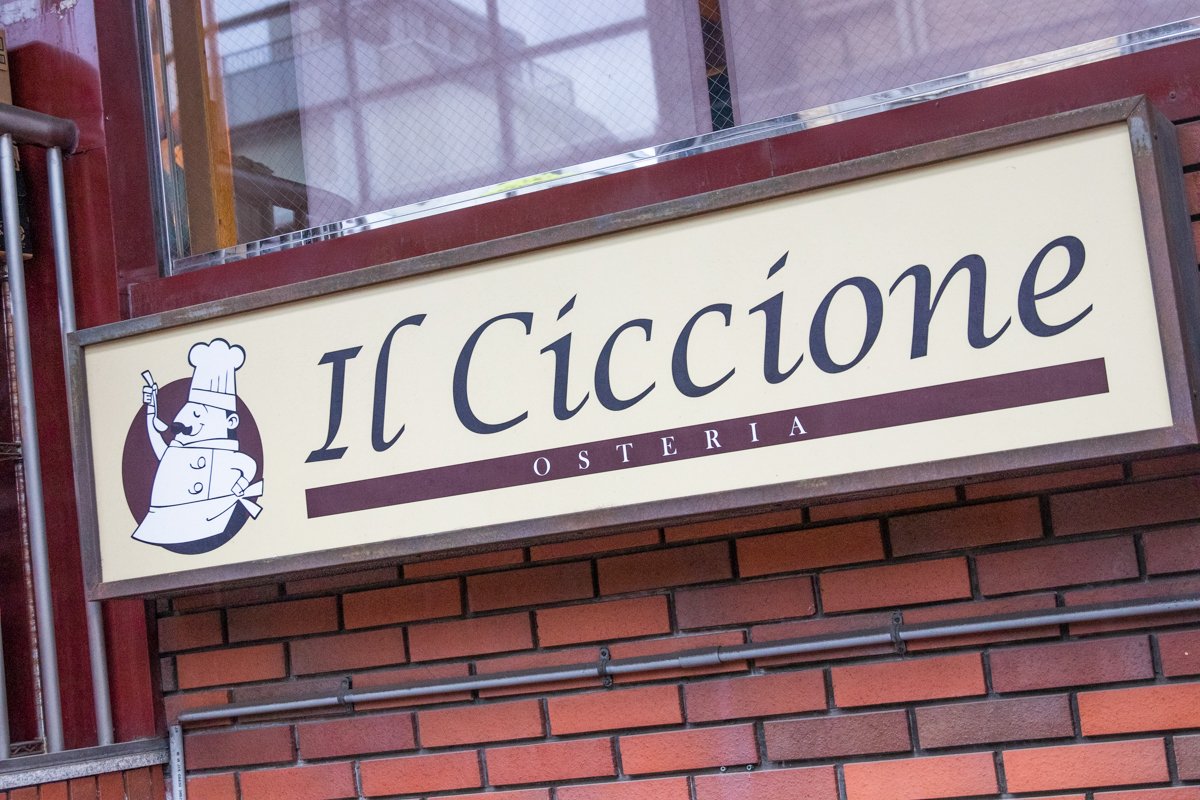 ロゴの可愛らしい「OSTERIA Il Ciccione」の看板