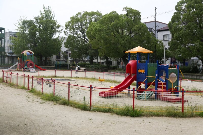 柵で囲まれた遊具広場では、小さな子供たちが遊ぶことができる