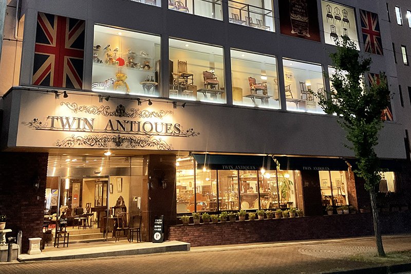 「ツインアンティークス イギリスアンティーク家具専門店」の夜間ライトアップ
