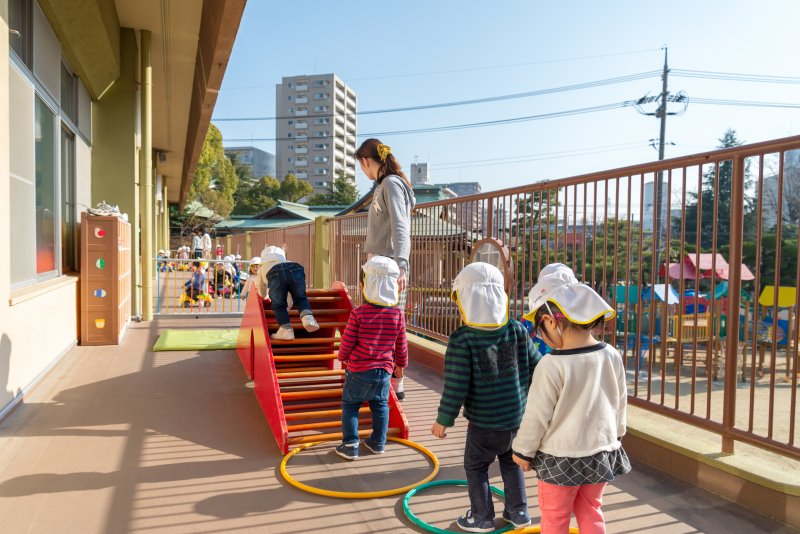 先生に見守られながら遊ぶ幼児たち