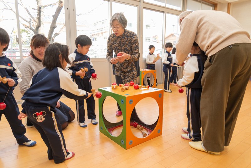 地域の方々に昔遊びを教えてもらう園児たち